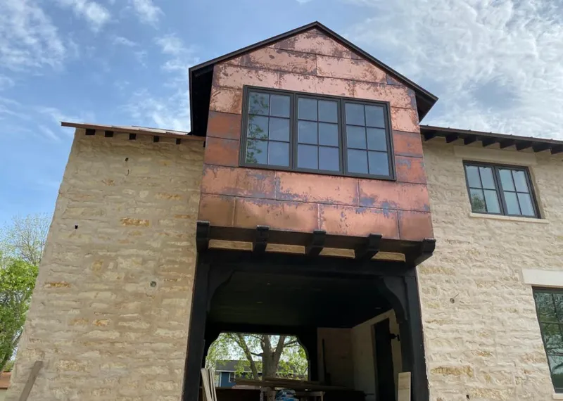 Copper metal panel facade on a stone building for Roof Repair in North Oaks